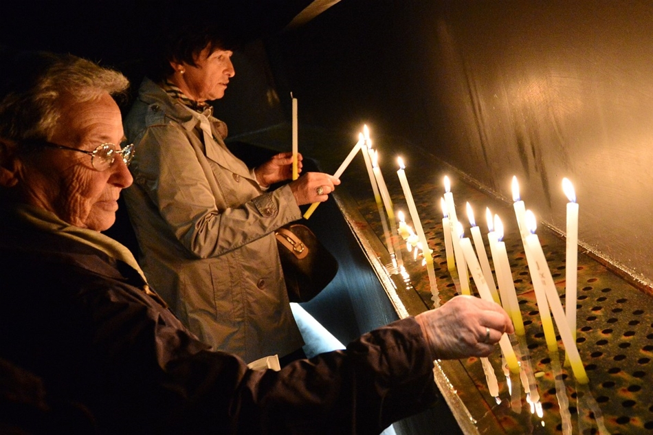 Sotto il Monte Giovanni, Olaszország - zarándokok gyújtanak gyertyát a Szent János templom kriptájában