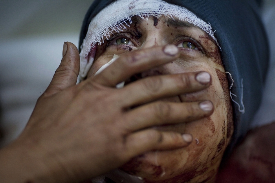 Aida nevű sebesült nő siratja férjét és két gyermekét, miután a szíriai kormányerők lebombázták a házát.