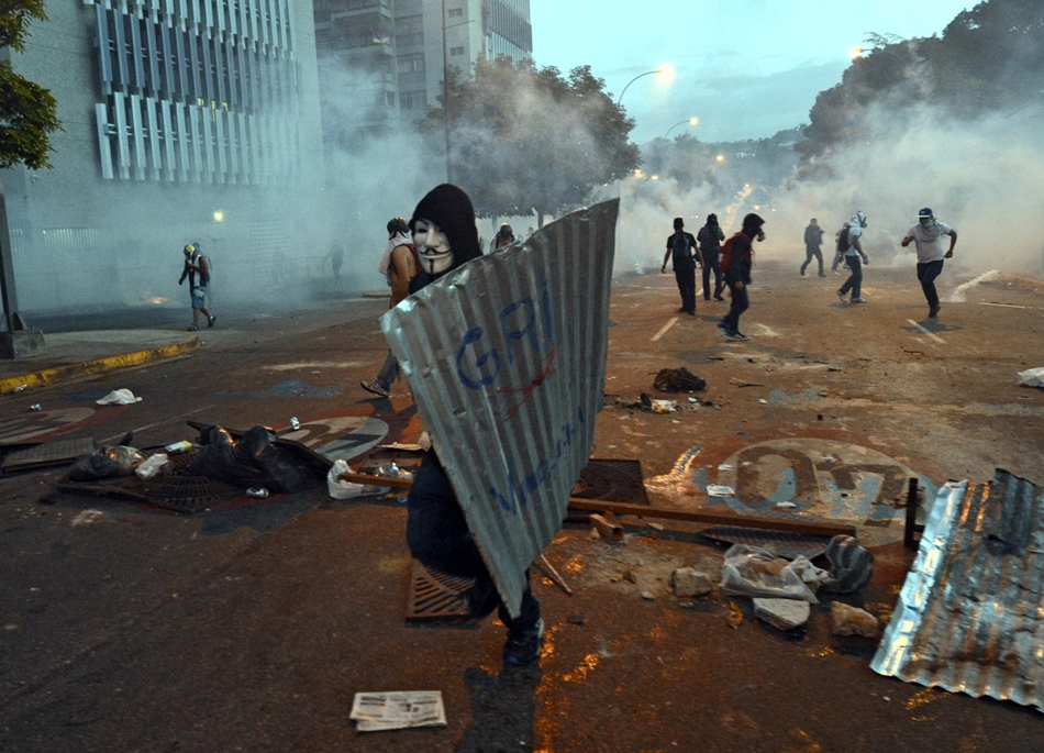 Caracas, Venezuela: tüntetők készülődése a belvárosban. A hetek óta tartó összecsapásokban a jórészt diákokból álló tüntetők Nicolás Maduro elnök lemondását követelik, s a baloldali populista államfőt és rendszerét teszik felelőssé azért, hogy elszabadult a bűnözés, az infláció meghaladja az 56 százalékot, és alapvető termékekből – egyebek mellett vécépapírból, étolajból és kukoricalisztből – is hiány van az amúgy a világ legnagyobb ismert olajkészleteivel rendelkező Venezuelában. Korábbi beszámolók alapján az ellenzékiek szerint a hatóságok erőszakkal próbálják elfojtani a tiltakozást, s a nemzeti gárda és a collectivos néven ismert radikális kormánypárti fegyveres csoportok tagjai több alkalommal rálőttek a demonstrálókra.