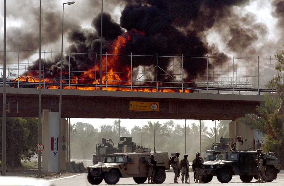 2004. szeptember 18. - amerikai konvoj járművei lángolnak Bagdadban egy útszéli pokolgép robbanása után